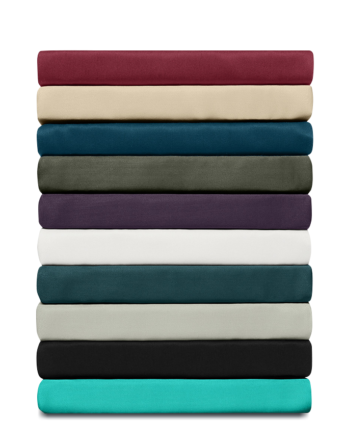 Stapel gevouwen lakens in diverse kleuren, netjes gerangschikt om kleuropties en stofkwaliteit te tonen.